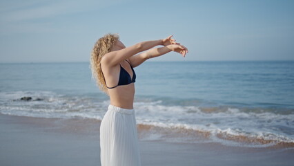 Fototapeta na wymiar Gentle dancer moving body sensually on summer beach. Beautiful woman dancing