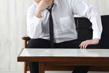 自宅のソファで頭を抱えるビジネスマン