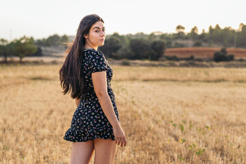 Portrait of a pretty young woman with long hair in the countryside