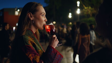 Woman drinking cocktail street party evening close up. Girl enjoying party night