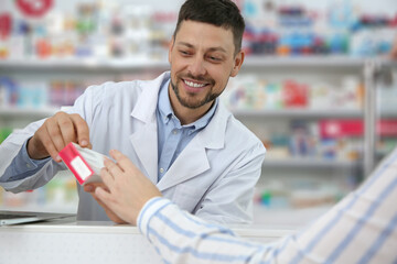 Professional pharmacist giving medicine to customer in drugstore