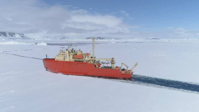Antarctic Icebreaker Ship Float Ice Aerial View Shot. Laurence M. Gould Research Boat Float Through Southern Ocean Frozen Glacier on Mountain Landscape Top Tracking Drone View