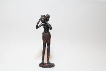 Ebony figure of a woman carrying a vase in white background.