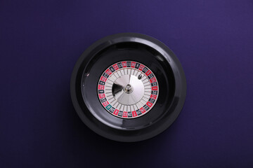 Roulette wheel with ball on dark violet background, top view. Casino game
