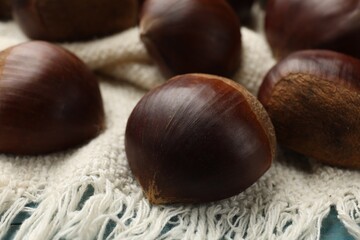 Roasted edible sweet chestnuts on table, closeup