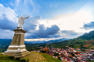 Christ the Redeemer on top of a hill with the town of Jerico in the background in Colombia
