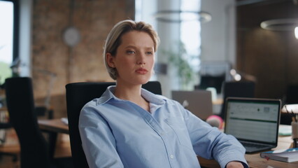 Fototapeta premium Portrait confident businesswoman sitting modern office. Lady boss looking camera