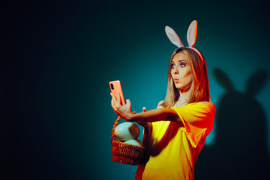 Funny Woman Taking a Selfie Celebrating Easter with Bunny Ears. Cheerful girl in festive mood communicating via video call
