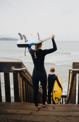 Surfers walking down steps towards ocean