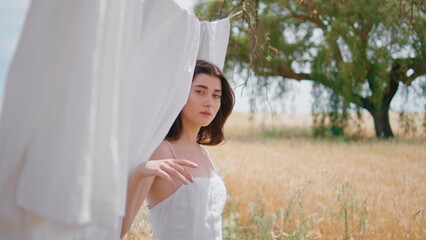 Naklejka premium Young lady appearing laundry hanging countryside portrait. Woman looking camera