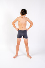 Obraz premium Preteen male fitness model standing shirtless with hands on hips looking downward