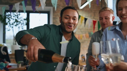 Excited colleagues clinking glasses with wine celebrating in office close up.