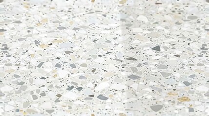 a square tile featuring a high-definition terrazzo pattern, with small to medium-sized flecks of grey, white, and beige on a bright background. The tile is laid out on a floor with subtle reflections