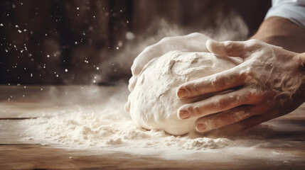 Hands press and fold dough amid a cloud of flour on a rustic kitchen table. Bakery concept. - obrazy, fototapety, plakaty