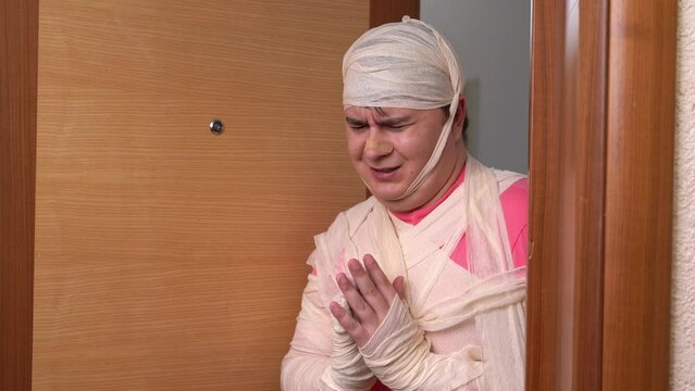 Man expresses gratitude to medical staff with confident nod. Guy wrapped in bandages closes door to examination room showing sign of agreement