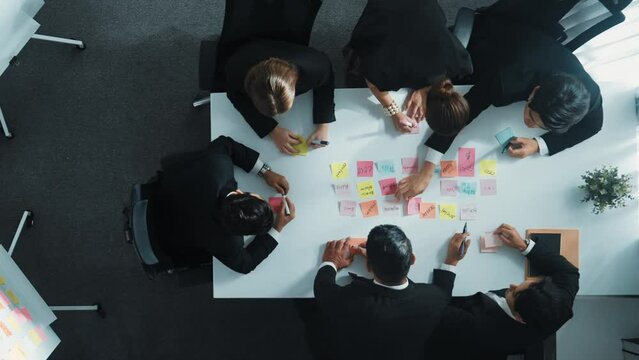 Top view of smart business team planning marketing strategy at meeting room. Professional executive manager exchange data and brainstorm idea while writing in sticky notes at workplace. Directorate.