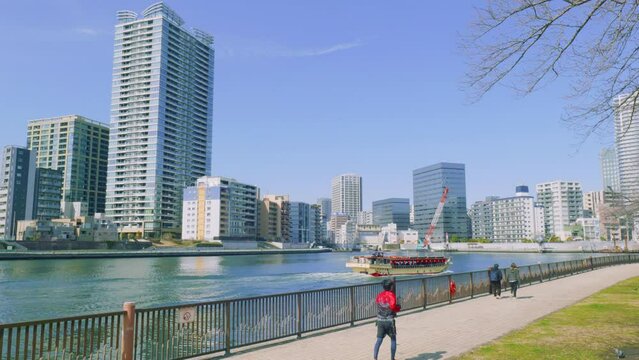 青空の隅田川の屋形船と高層ビル群