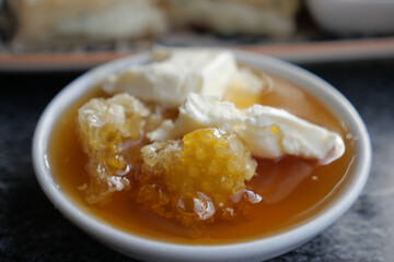 butter cream and honey in a bowl on table .