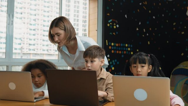 Smart teacher teaching and looking student using laptop at classroom. Professional instructor explained about programing engineering code or prompt while studying and learning program. Erudition.