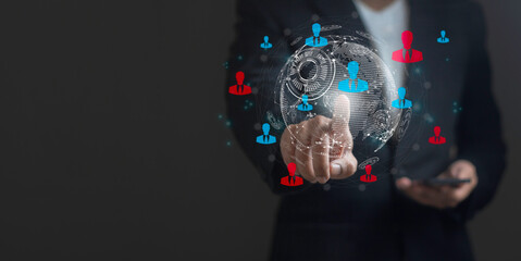 A man is pointing at a globe with a red, blue, and green dot on it