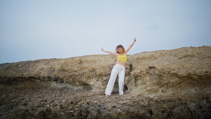 Attractive woman dancer performing sensual choreography on summer nature. 
