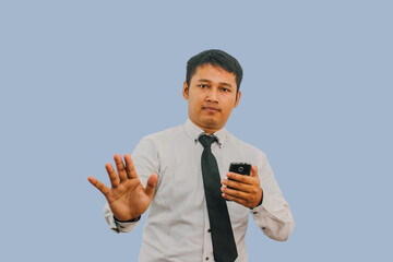 Adult Asian man showing stop hand sign when looking to his mobile phone screen