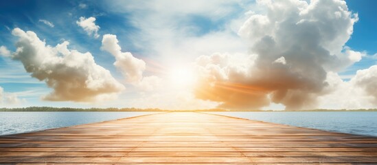 A wooden pier stretching into the water under the sun piercing through the clouds, creating a...