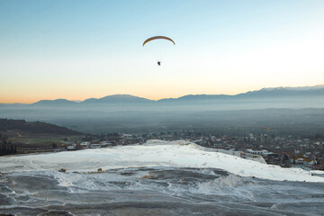 Paraglider flying over landscape sunrise. Concept of extreme sport, taking adventure challenge.