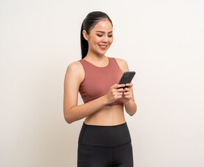 Young beautiful asian woman with sportswear using smartphone on isolated white background. Attractive Portrait latin sporty woman standing pose holding cell phone exercise workout in studio.