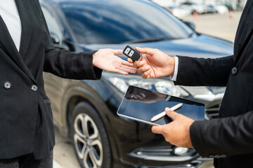Young asian businesswoman buying new car with sale manager signing signature deal on tablet getting...