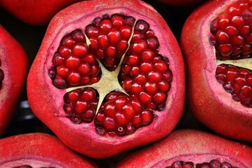 A crimson pomegranate, bursting with ruby-red seeds, symbolizes fertility, abundance, and exotic...