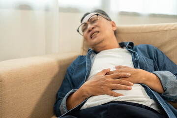 Old man senior had a stomach ache and gastritis. Mature man put hand on his stomach and squeezed it...