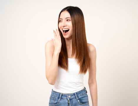 Clean breath fresh breath. A woman with good oral health beautiful teeth clean and no bad breath. She sniffed at her mouth covering it with her hand standing on isolated background