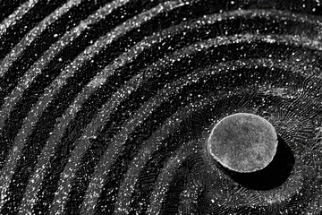 Foto op Aluminium A black zen garden, raked patterns in the stone. The photographer captures tranquility and balance © Formoney