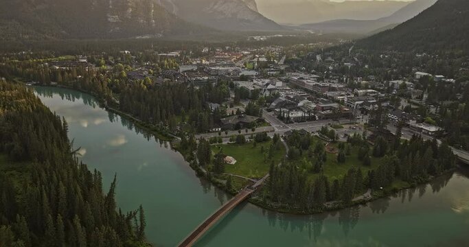 Banff AB Canada Aerial v18 flyover town capturing pristine Bow river with turquoise water, quaint townscape with forested valleys and mountainous surroundings - Shot with Mavic 3 Pro Cine - July 2023