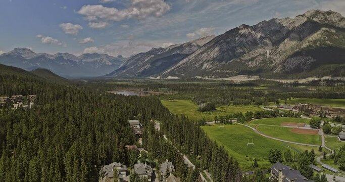Banff AB Canada Aerial v36 drone flyover forested valley capturing residential houses, horse stables and panoramic views of Norquay and Cascade mountain ranges - Shot with Mavic 3 Pro Cine - July 2023
