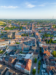 Obraz premium This is an aerial image capturing the heart of Halle, Belgium, in the gentle embrace of the golden hour. The towns historic charm interweaves with modern updates, as terracotta rooftops mingle with