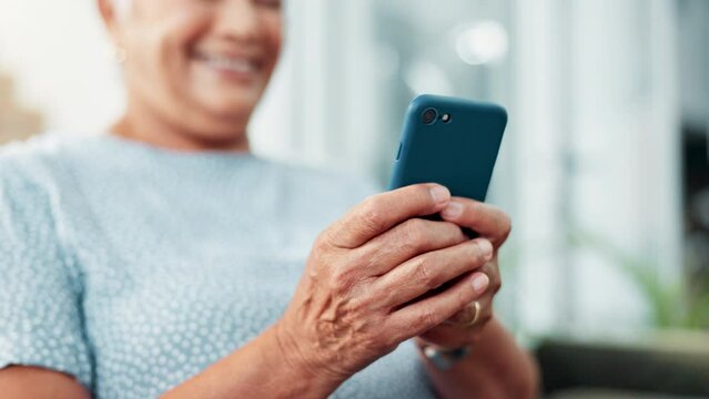 Senior, woman and hands typing with phone for communication, social media or networking on sofa at home. Closeup of elderly female person with smile on mobile smartphone in online chatting or texting