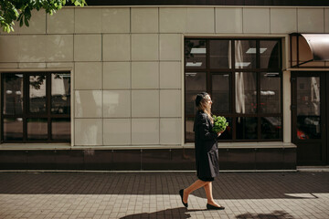 Woman Walking Down Street With Green Bag