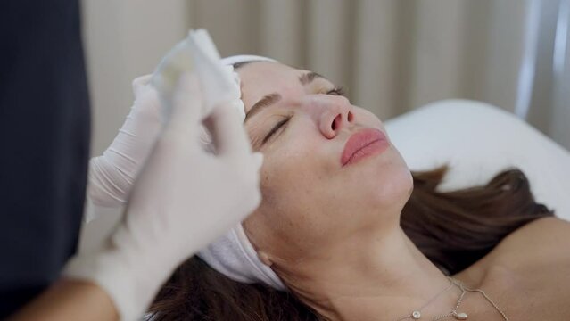 botox facial treatment. cosmetologist marks with a pen the injection site for Botox on the patient&rsquo;s forehead. Preparing face for botox injection. Woman getting face beauty cosmetic treatment.