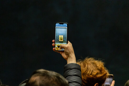 Le Louvre, France, November 9, 2023: Smartphone capturing Mona Lisa painting.