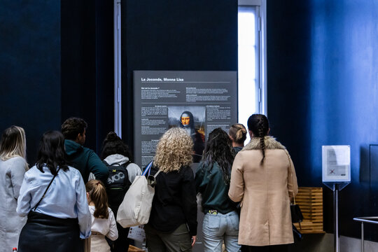 Paris, France, November 9, 2023: Visitors admiring the Mona Lisa in the Louvre Museum.