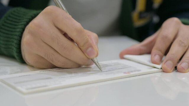 Man writing on a cheque, Banking