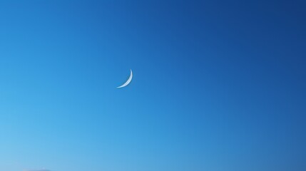 Obraz na płótnie Canvas Morning serenity: a crescent moon against a clear blue sky, capturing the peacefulness of dawn.
