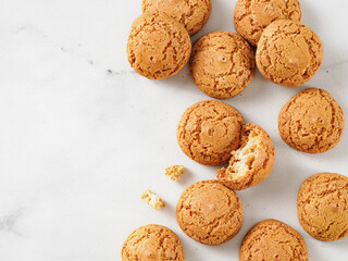 pile of cookie amaretti on white marble background - traditional Italian Sardinian pastry. Delicious amaretti biscuit cookies made from almond or apricot kernels with copy space