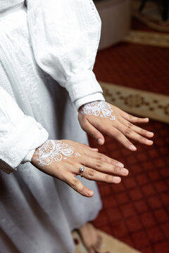 Close up of white henna arts on the bride's hand. bride's hands in shape of love heart - Image