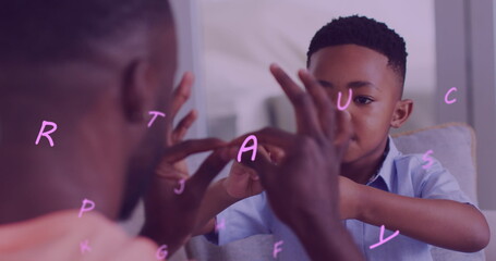 Image of letters floating over happy african american father and son playing finger games