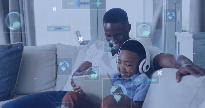 Image of technology icons over happy african american father and son using tablet