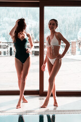 Two sexy women swim in the pool.Womans relaxes in the spa.Relaxation concept in the hotel