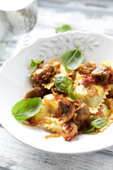 Ravioli with mushrooms and fresh basil. Bright wooden background. Close up.	